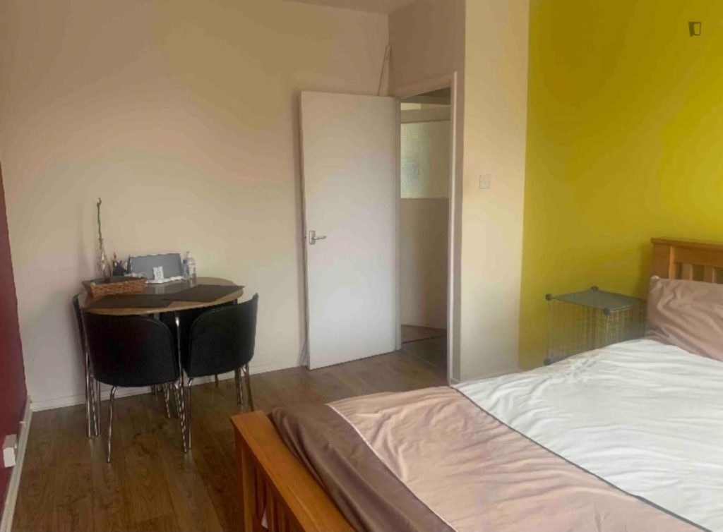 Chambre meublée avec bureau et chaises.