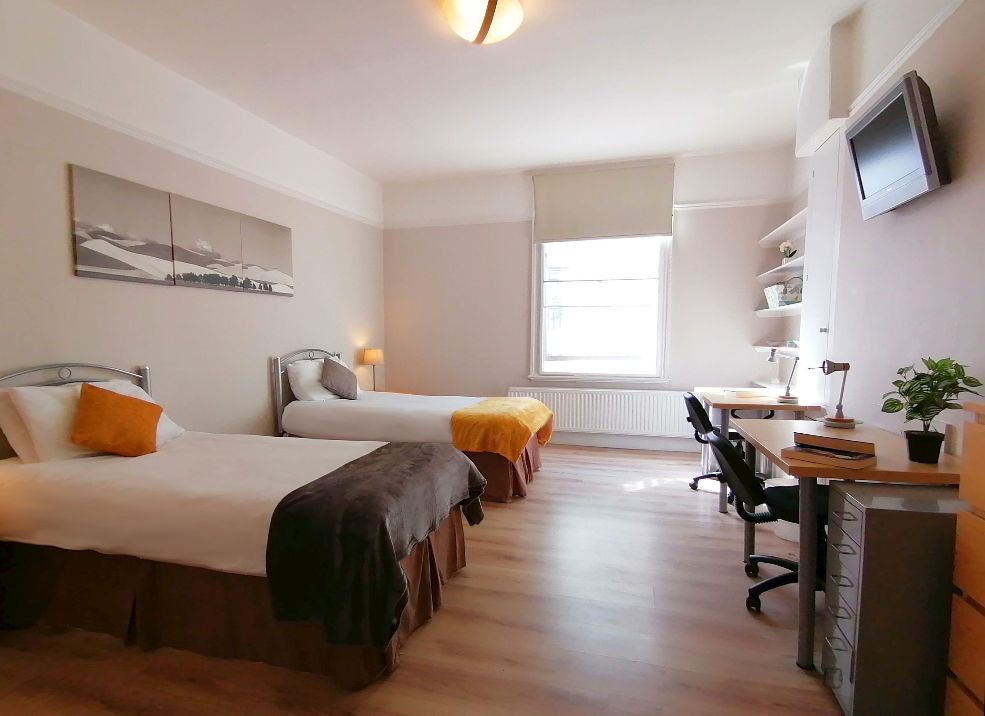 Voici la Colocation que nous vous proposons : Rathbone, Soho, W1T, London– Appartement en Colocation de seulement deux chambres (petite Colocation). Vous louerez une des deux chambres qui sont chacune très spacieuses, parfait pour 2 personnes. Les chambres sont très grandes et prévues pour des étudiants avec deux lits doubles, deux bureaux, TV, armoire, tables de nuit, commode et/ou rangements. – Il s’agit d’une Colocation exclusivement ouverte aux étudiants, pas aux professionnels. – L’immeuble dispose d’une localisation unique, en plein centre de Londres et à l’entrée du quartier mythique de Soho. Emplacement génial pour profiter de la ville. De plus, la station de Tottenham Court Road est à seulement 3 mn à pied, avec plusieurs lignes de métro et notamment la très rapide Elizabeth Line. Logement sécurisé.Logement entièrement meublé et aménagé avec meubles et rangements. Le logement dispose d’une cuisine plutôt moderne (bien équipée avec micro-onde, bouilloire, fer à repasser,…) avec table et chaises, d’une Salle de bain avec baignoire + WC. Machine à laver avec fonction sèche-linge. – Ménage hebdomadaire du logement inclus dans le loyer + changement du linge de lit. Serviette de bain incluse. – Toutes les charges sont incluses dans le loyer, Internet compris. – Quartier unique, très dynamique et vivant, dans l’hyper-centre de Londres. Soho Square Gardens à 5min de marche, le British Museum à 10min et Oxford Circus à seulement 600m.
